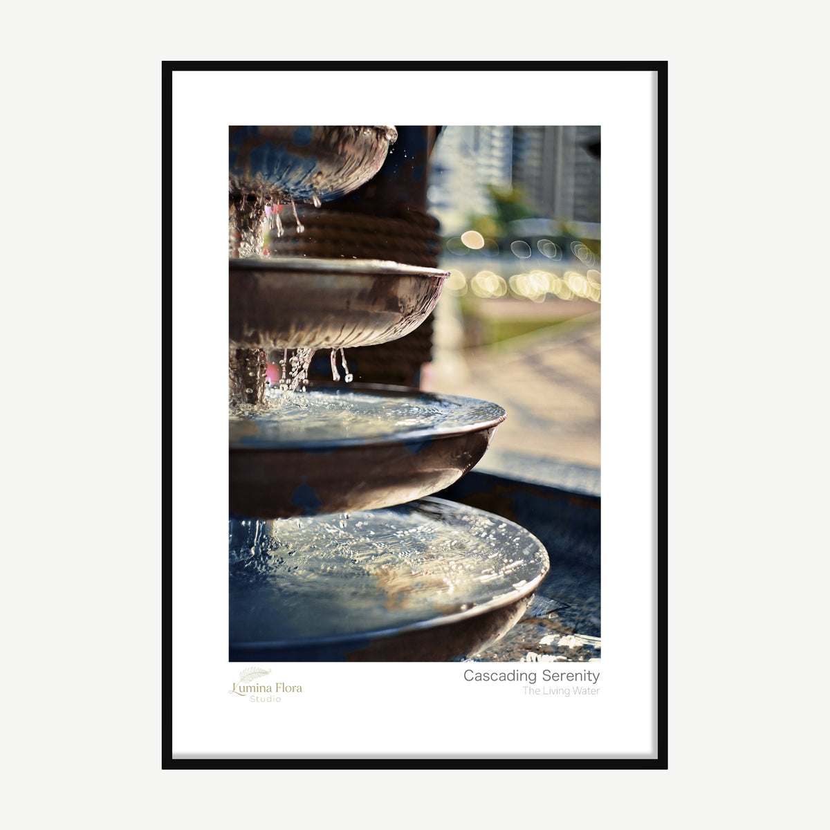 Framed print: water trickling over bronze fountain tiers with golden bokeh, black wood frame