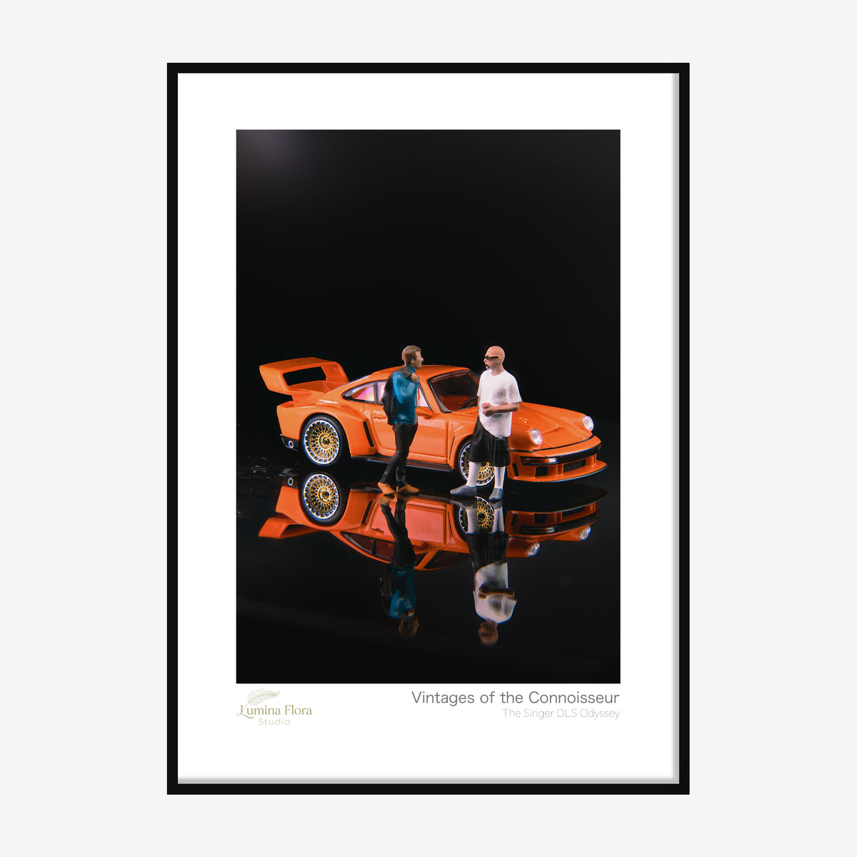 Framed print: miniature figures beside an orange classic car model, black wood frame