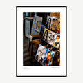 Framed print: charcoal caricature drawings displayed on street easels, black wood frame